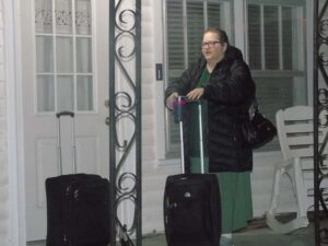 lady with coat and suitcases